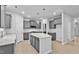 Bright kitchen features gray cabinets, stainless appliances, large island with stone countertop, and light wood floors at 2750 Lacy Holt Rd, Graham, NC 27253