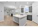 Bright open-concept kitchen with gray cabinets, stone countertops, stainless appliances, and an island at 2750 Lacy Holt Rd, Graham, NC 27253