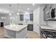Bright kitchen featuring gray cabinets, stone countertops, and stainless appliances at 2750 Lacy Holt Rd, Graham, NC 27253