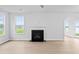 Bright living room features hardwood floors, fireplace, and backyard view through large windows at 2750 Lacy Holt Rd, Graham, NC 27253