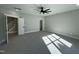 Bright bedroom featuring carpet, ceiling fan, and access to stairs at 314 Hinton St, Apex, NC 27502