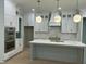 Modern kitchen with white cabinets, center island, and quartz countertops at 314 Hinton St, Apex, NC 27502