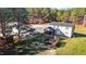 Expansive backyard featuring a deck, playset, lush lawn, and bordered by mature trees at 3214 Tump Wilkins Rd, Stem, NC 27581