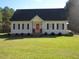 Charming single-story home with a well-maintained lawn and an inviting red front door at 3214 Tump Wilkins Rd, Stem, NC 27581