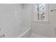 White bathtub with a window overlooking the backyard at 35 Arbor Dr, Youngsville, NC 27596