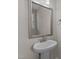 Pedestal sink with a framed mirror in a small bathroom at 35 Arbor Dr, Youngsville, NC 27596