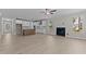 Open-concept living room with fireplace, ceiling fan, and kitchen with white cabinets and stainless appliances at 35 Arbor Dr, Youngsville, NC 27596