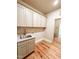 Functional laundry room with a sink, ample cabinet space, and hardwood floors at 505 Rossie Jones Rd Rd, Zebulon, NC 27597