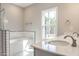 Bright bathroom with a large window, soaking tub, subway tile, and white vanity with dual sinks at 6967 Jefferson Davis Hwy, Cameron, NC 28326