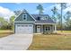 Newly built home with green siding, white trim, and a two-car garage at 6967 Jefferson Davis Hwy, Cameron, NC 28326