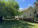 View of home's backyard featuring brick foundation, exterior siding, and landscaping, offering a private outdoor space at 1200 Carolina St, Graham, NC 27253