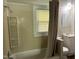 Bathroom featuring a shower-tub combo, neutral walls, and a vanity with sink, providing essential functionality and comfort at 1200 Carolina St, Graham, NC 27253