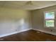 Bright bedroom featuring wood floors, neutral walls, and a window offering natural light and a view of the outdoors at 1200 Carolina St, Graham, NC 27253