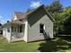 Side view of a charming home with neutral siding and brown roof, showcasing its simple architecture and well-maintained exterior at 1200 Carolina St, Graham, NC 27253