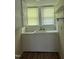 Well-lit utility sink area featuring built-in cabinets, a white sink, and ample storage for kitchen essentials at 1200 Carolina St, Graham, NC 27253