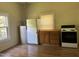 Functional kitchen equipped with laminate floors, essential appliances, and wooden cabinets, ready for your culinary creations at 1200 Carolina St, Graham, NC 27253