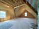 Unfinished attic space with wood beams and natural light from windows at 7575 Sweetwater Dr, Nashville, NC 27856