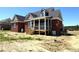 Backyard view of brick house with screened-in porch and wooden stairs leading down at 7575 Sweetwater Dr, Nashville, NC 27856