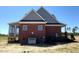 The backside of a brick home with a screened-in porch and a well-maintained lawn at 7575 Sweetwater Dr, Nashville, NC 27856