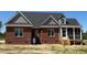 Rear exterior view showing a brick home with a screened-in porch, offering a blend of indoor-outdoor living at 7575 Sweetwater Dr, Nashville, NC 27856