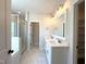 A luxurious bathroom offers a glass shower, dual sinks, and a view into a walk-in closet at 7575 Sweetwater Dr, Nashville, NC 27856