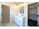 Bright bathroom features double vanity, tile flooring, framed mirror, decorative lights, and a walk-in closet at 7575 Sweetwater Dr, Nashville, NC 27856