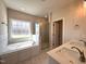 A luxurious bathroom offers double sinks, soaking tub, and glass shower with modern fixtures at 7575 Sweetwater Dr, Nashville, NC 27856