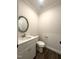 Half-bath features white vanity and toilet, a mirror and hard-wood flooring at 7575 Sweetwater Dr, Nashville, NC 27856