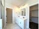 A bright bathroom features dual sinks, modern fixtures, and a walk-in closet nearby at 7575 Sweetwater Dr, Nashville, NC 27856