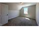 Bedroom featuring neutral carpet, window, and ensuite closet space at 7575 Sweetwater Dr, Nashville, NC 27856