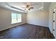 A sunlit bedroom showcases dark wood floors and a large window with lovely natural views at 7575 Sweetwater Dr, Nashville, NC 27856