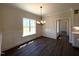 Bright dining room featuring wainscoting, a chandelier, large window and dark floors at 7575 Sweetwater Dr, Nashville, NC 27856