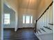 Inviting foyer with hardwood floors, staircase, and a view into the adjacent living room at 7575 Sweetwater Dr, Nashville, NC 27856