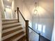 Grand foyer with wood stairs, white railing, globe light fixture, and ample natural light shining through the front door at 7575 Sweetwater Dr, Nashville, NC 27856