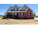 Charming two-story brick home with black shutters, a well maintained lawn, and a concrete sidewalk at 7575 Sweetwater Dr, Nashville, NC 27856