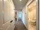 Bright hallway leading to a bathroom and bedrooms, featuring neutral carpet, and fresh paint at 7575 Sweetwater Dr, Nashville, NC 27856