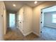 Neutral hallway with multiple rooms and closets leading into a bedroom with a large window at 7575 Sweetwater Dr, Nashville, NC 27856