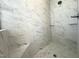 Close-up of walk-in shower with marble style tilework and glass shelving at 7575 Sweetwater Dr, Nashville, NC 27856