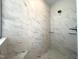 A walk-in shower with marble-style tilework and glass shelving at 7575 Sweetwater Dr, Nashville, NC 27856