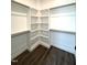 Bright walk-in closet with white shelving and hanging rods provides ample storage space and a modern look at 7575 Sweetwater Dr, Nashville, NC 27856