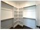 Spacious walk-in closet with custom white shelving and hanging rods on a dark hardwood floor, perfect for organization at 7575 Sweetwater Dr, Nashville, NC 27856