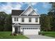 Exterior elevation of a white two-story home with a black roof, white garage door and a manicured lawn at 8816 Melvin St # 15, Willow Springs, NC 27592