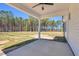 Inviting covered back patio with ceiling fan overlooks expansive, grassy backyard and natural wooded area at 91 Laramie Ln, Selma, NC 27576
