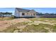 Spacious backyard view featuring a charming white home with black accents and unfinished landscaping at 91 Laramie Ln, Selma, NC 27576