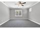 A spacious bedroom is brightened with large windows, plush carpet, and a modern ceiling fan at 91 Laramie Ln, Selma, NC 27576