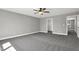 A spacious carpeted bedroom featuring a modern ceiling fan, walk-in closet, and a neutral palette at 91 Laramie Ln, Selma, NC 27576