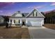Beautiful single-Gathering home with a large two-car garage and covered front porch under a colorful sky at 91 Laramie Ln, Selma, NC 27576