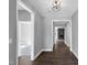 Hallway with beautiful dark wood floors leading to the living room with a stone fireplace at 91 Laramie Ln, Selma, NC 27576