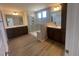 Spacious bathroom showcasing dual vanities, a glass-enclosed shower with tile surround, and wood look floors at 113 Arundel Dr, Archer Lodge, NC 27527