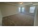 Spacious bedroom with plush carpeting, three light-filled windows, and a trey ceiling at 113 Arundel Dr, Archer Lodge, NC 27527